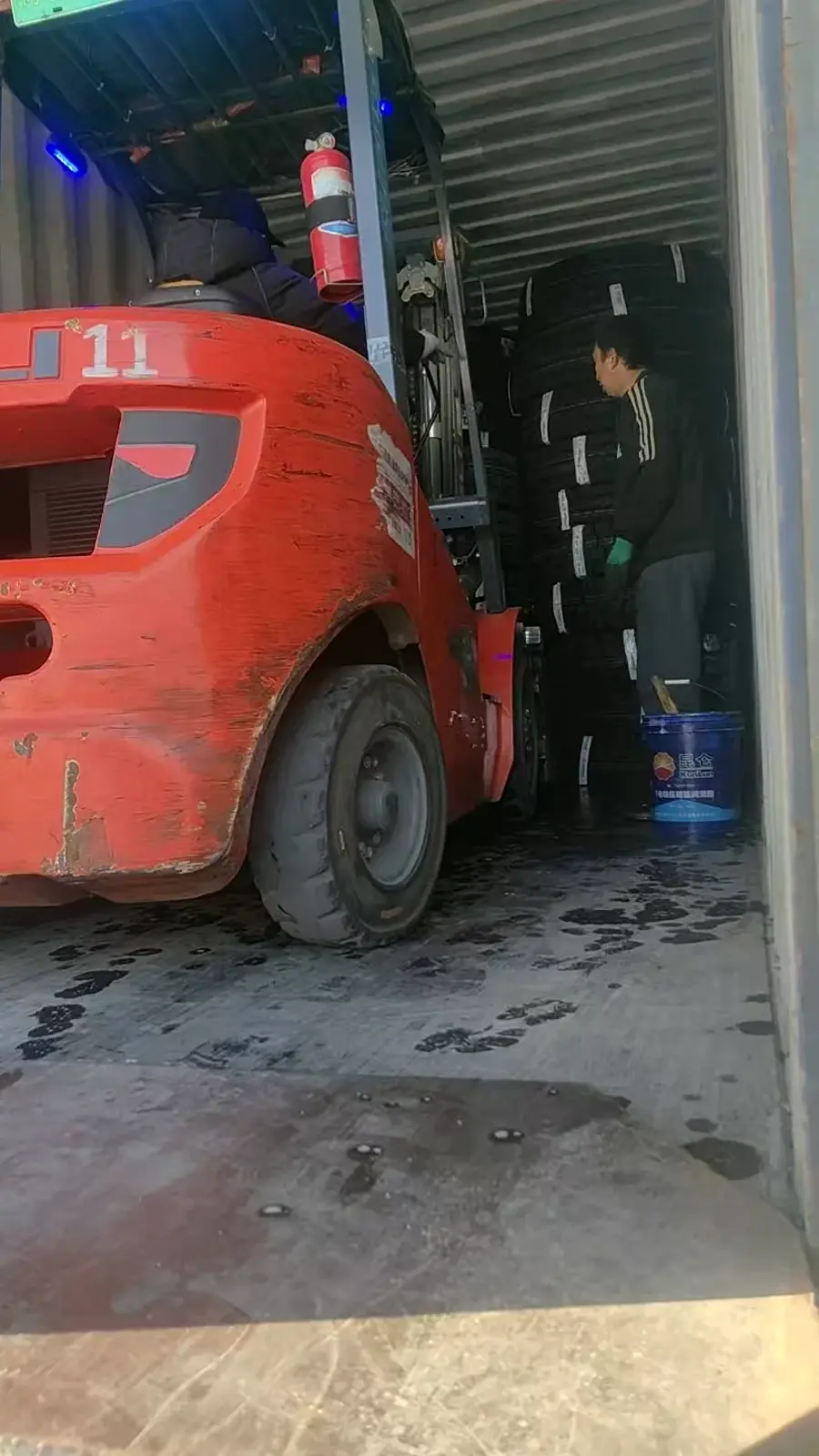 Forklift loading TBR truck tires into a container